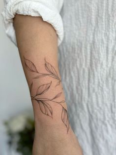 a woman's arm with a small tattoo design on the left side of her arm