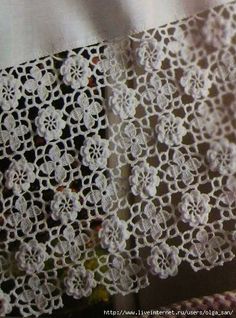 white crocheted lace is hanging on the wall