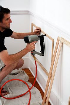 a man using a power drill to paint a wall