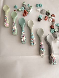 there are many spoons that have different designs on them, including beads and seashells