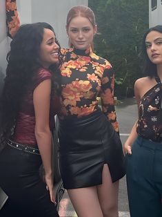 three beautiful women standing next to each other