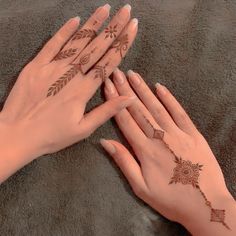 two hands with henna tattoos on their palms