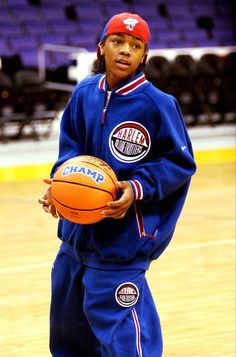 a young man holding a basketball on top of a court