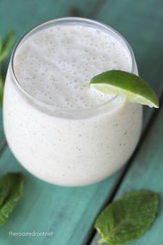 a smoothie in a glass with a green garnish on top