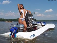 a woman in a white swimsuit standing on a small boat with an engine attached to it