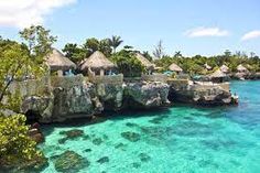 the water is crystal blue and clear with some huts on it's cliffs in front of