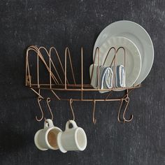 a metal rack holding plates and cups on top of a black tablecloth covered floor