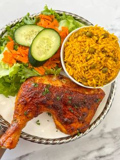 a white plate topped with meat and rice next to a bowl of veggies