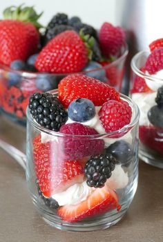 berries, strawberries and blueberries are in small glass bowls