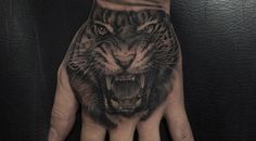 a hand with a tiger tattoo on it