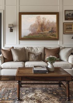 a living room filled with furniture and a painting on the wall above it's coffee table