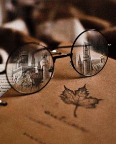 a pair of glasses sitting on top of an open book with a leaf drawn on it