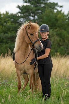 a woman standing next to a brown horse