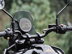 a close up view of the handlebars and gauges on a black motorcycle