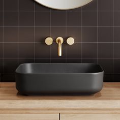 a black bath tub sitting under a round mirror