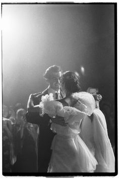 black and white photograph of bride and groom dancing at their wedding reception in front of an audience