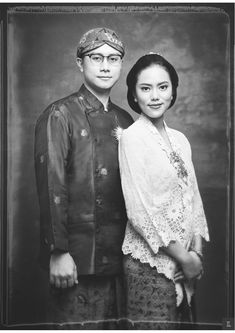 an old black and white photo of a man and woman posing for a portrait together