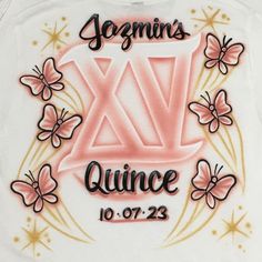 a white shirt with pink flowers and butterflies on the front, says geranis x's quince 10 07 - 23