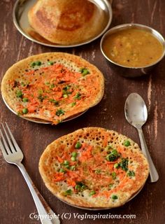 three small pizzas with different toppings and silver spoons on a wooden table