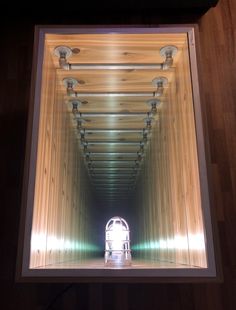 an instagramted photo of the inside of a wooden tunnel with lights coming from it