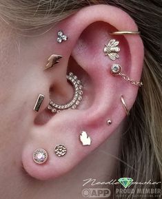 an ear with several different piercings attached to it's sides and behind the ear