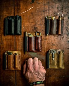 a man's hand is pointing at several leather items