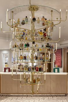 a chandelier in the middle of a room filled with bottles and glasses on shelves