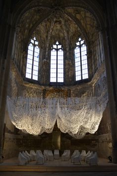 the interior of an old church with white chairs and chandelier