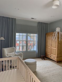 a baby's room with a crib, rocking chair and dresser in it