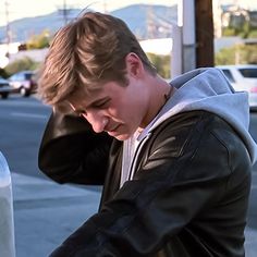 a young man leaning on a parking meter