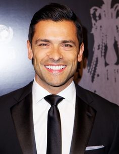 a man in a suit and tie smiling for the camera