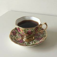 a tea cup and saucer sitting on top of a white countertop next to a wall