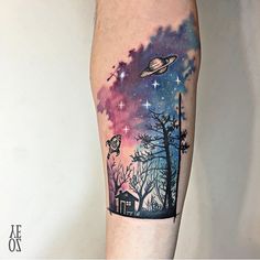 a person with a tattoo on their leg that has an image of the sky and trees