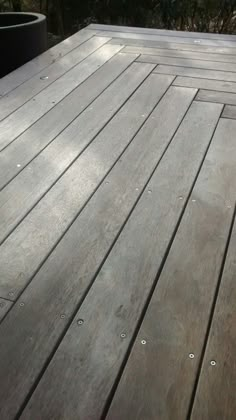 a cat sitting on top of a wooden deck