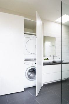 a white washer and dryer in a room with black tile on the floor