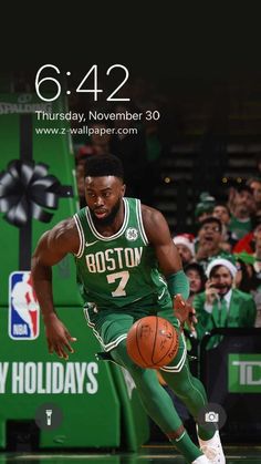 boston basketball player dribbling the ball in front of an audience at a game