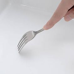 a person holding a fork in their left hand and pointing to it on the other side