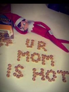 an elf laying on top of a table with cereal spelled out in the shape of letters