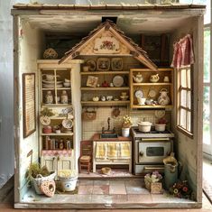 a doll house with shelves, pots and pans