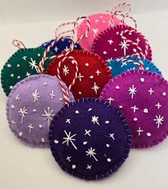 several different colored ornaments with white snowflakes on them