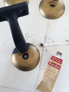 a close up of a metal object on the ground near a tube of toothpaste