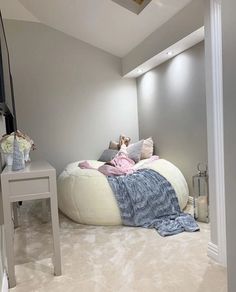 a bedroom with a large bean bag bed on the floor and a small table next to it