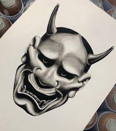 a drawing of a demon mask with horns on it's head and two eyes