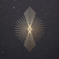 an image of a starburst in the middle of some black paper with gold foil on it