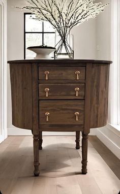 a wooden table with drawers and a vase on top