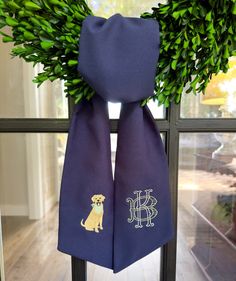 a purple scarf with a golden retriever on it hanging in front of a window