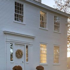 a white house with two wreaths on the front door