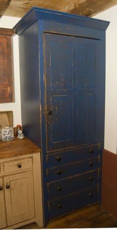 an old blue armoire in the corner of a room