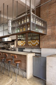 an industrial style bar with stools and tiled back splashing on the wall behind it