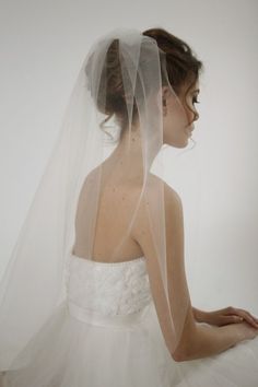 a woman wearing a white wedding dress and veil